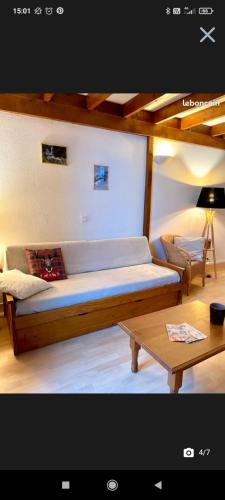 - une chambre avec un lit et une table basse dans l'établissement Appartement T2 Guzet Neige, à Ustou
