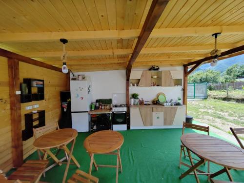 a kitchen and dining area of a house with wooden ceilings at Luna Rock Glamping Brezoi - Blue Scai in Brezoi