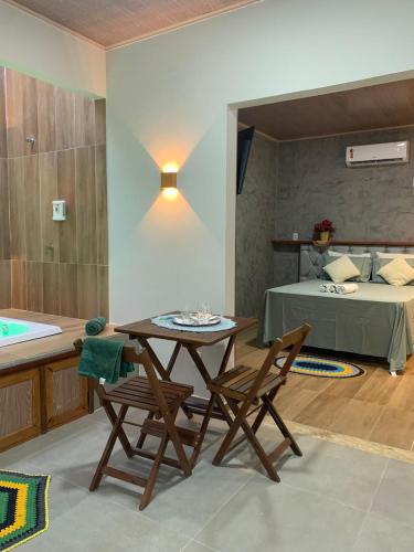 a room with a table and chairs and a bed at POUSADA IRMAOS ATINS in Atins