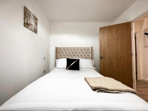 1 dormitorio con 1 cama blanca grande y puerta de madera en The SkyLine Apartment 2023 built, en Oxford