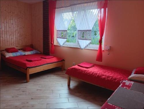 a bedroom with two beds and a window at U BLIŹNIAKÓW pokoje gościnne in Gąski
