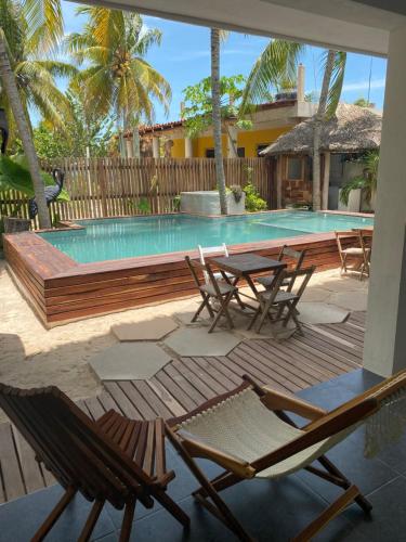 une terrasse avec des chaises et une piscine avec une table et des chaises dans l'établissement Ah Muzenkab, à El Cuyo