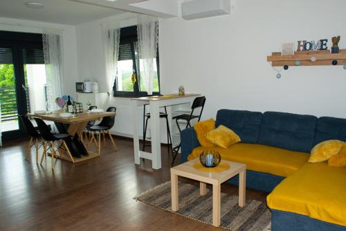 sala de estar con sofá azul y mesa en Kraljeva hiža - Apartmani i sobe Kralj, en Sveti Martin na Muri