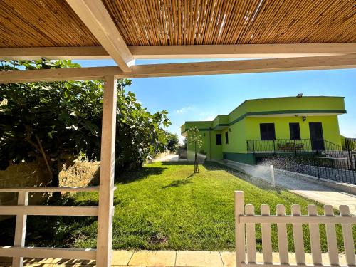 Blick auf ein Haus von einem Hof mit einem Zaun in der Unterkunft Mondoverde Apartments & Rooms in Surano