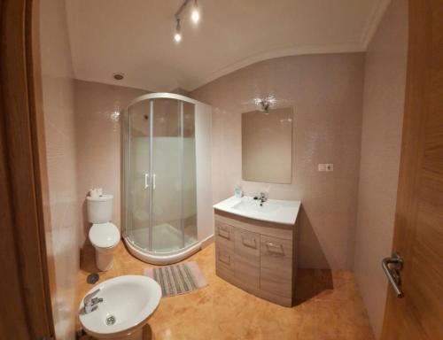 ein Bad mit einem Waschbecken, einer Dusche und einem WC in der Unterkunft MIRADOR DE GORGORIA in Foz