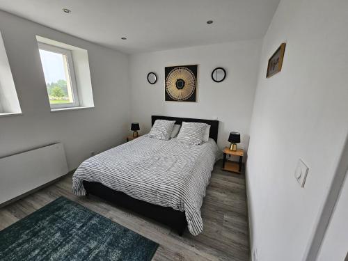 a white bedroom with a bed and a window at charmant appartement confort déco neuf , proche Epinal et Lac de Bouzey in Uxegney