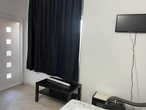 Sala de estar con cortina negra y mesa en Vila Vio 2 camere independente, en Eforie Nord