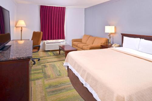 Habitación de hotel con cama y TV en Country Garden & Suites en Benton
