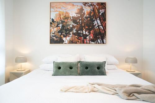 a bedroom with a bed with a painting on the wall at Cabot Views by Revelstoke Vacations in Revelstoke