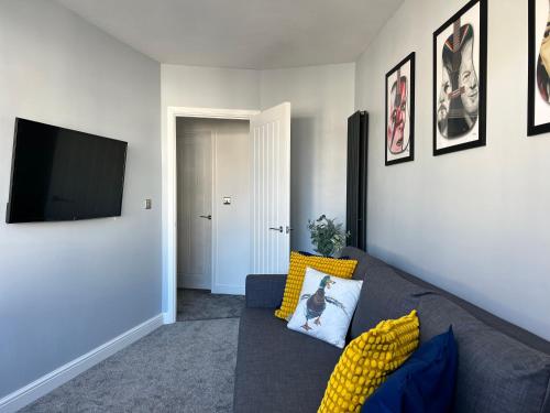 a living room with a couch and a flat screen tv at Luxury Retreat Beach House - Sleeps 6 in Southend-on-Sea