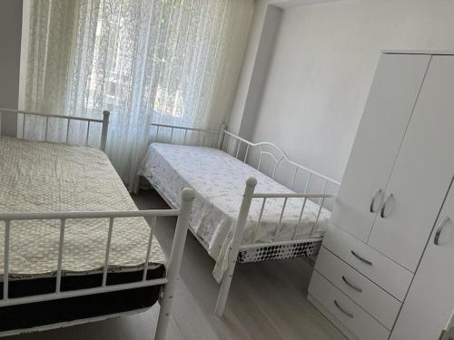 a bedroom with two beds and a dresser and a window at Müstakil Bahçeli Yazlık in Karasu