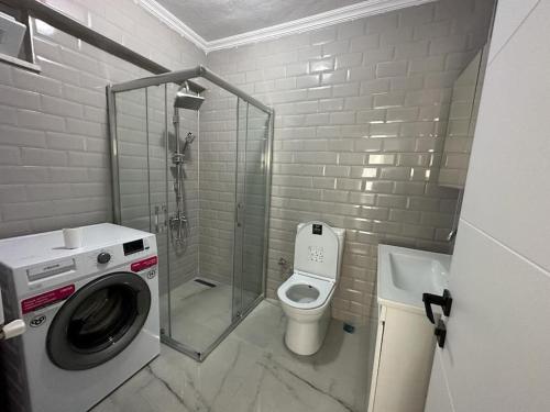a bathroom with a washing machine and a toilet at Müstakil Bahçeli Yazlık in Karasu