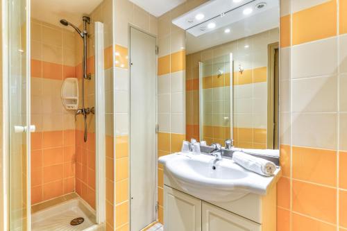 a bathroom with a sink and a shower at SOWELL HÔTELS Les Jardins du Cap in Cap d'Agde