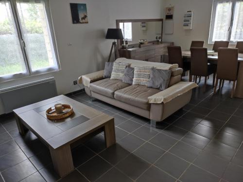 sala de estar con sofá y mesa en Magnifique maison Dans un village du Vexin en Ableiges