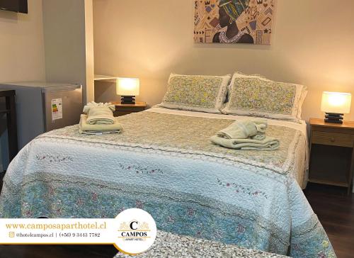 1 dormitorio con 1 cama con toallas en Hostal Campos Rancagua en Rancagua