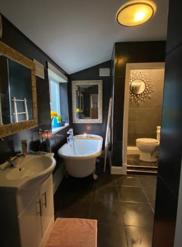 a bathroom with a tub and a sink and a toilet at Medway Getaway - 3 Bed Home with Luxury Bathroom in Chatham