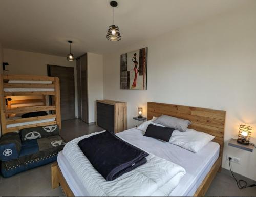 a bedroom with a large bed and bunk beds at Appartement Le Grand Duc in Gérardmer