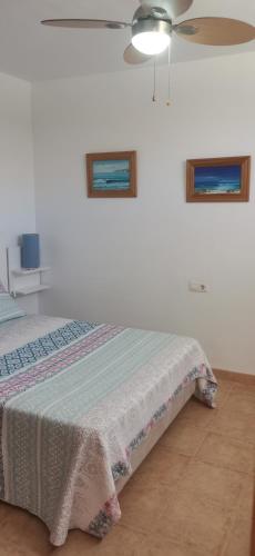 a bedroom with a bed and two pictures on the wall at Apartamento Relax Mojácar in Mojácar