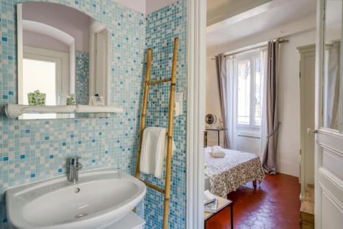 La salle de bains est pourvue de carrelage bleu, d'un lavabo et d'un miroir. dans l'établissement TYPIQUE - 2 bedrooms,Typical apartment-Old town Nice, à Nice