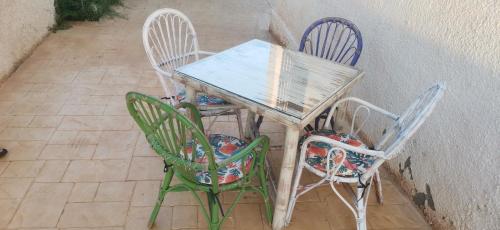 una mesa y cuatro sillas sentadas junto a una pared en Apartamento Relax Mojácar, en Mojácar
