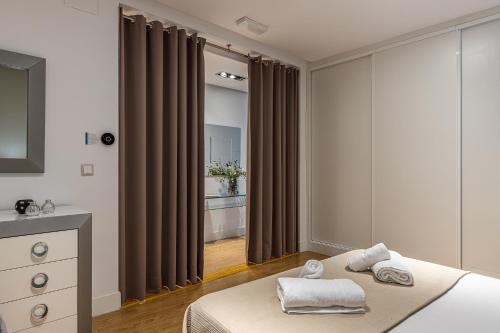 sypialnia z łóżkiem z ręcznikami w obiekcie BNBHolder Apartamentos en Sol Deluxe 1 w Madrycie