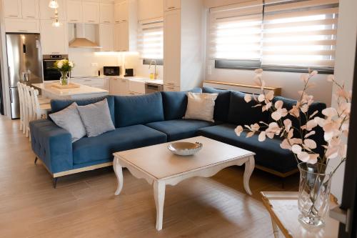 a living room with a blue couch and a table at ANESIS Luxury Apartment in Lefkada Town