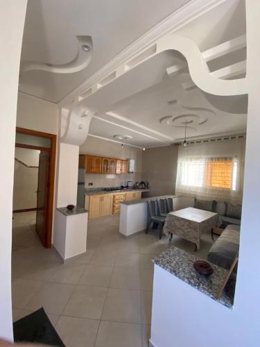 a living room with a table and a kitchen at Appartement proche de la corniche in Al Hoceïma