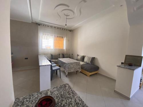 ein Wohnzimmer mit einem Sofa und einem Tisch in der Unterkunft Appartement proche de la corniche in Al Hoceïma