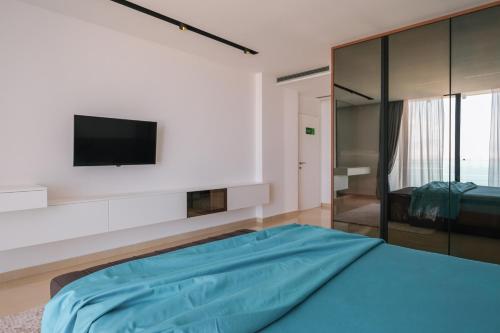 a bedroom with a bed and a tv on a wall at The Panoramic Villa in Široka