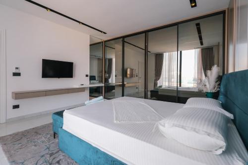 a bedroom with a bed and a tv on a wall at The Panoramic Villa in Široka