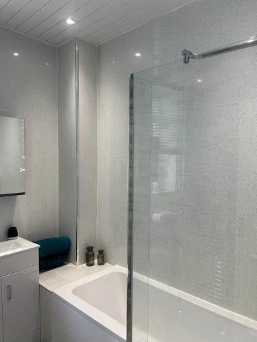 Das Bad ist mit einer Badewanne und einer Glasdusche ausgestattet. in der Unterkunft 1L Albert Place in Polmont