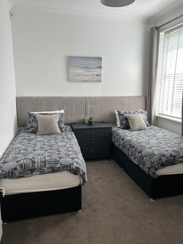a bedroom with two beds and a window at 1L Albert Place in Polmont