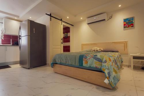 a bedroom with a bed and a refrigerator at Pierre's Place Grand-Case, a place to dream in Grand Case