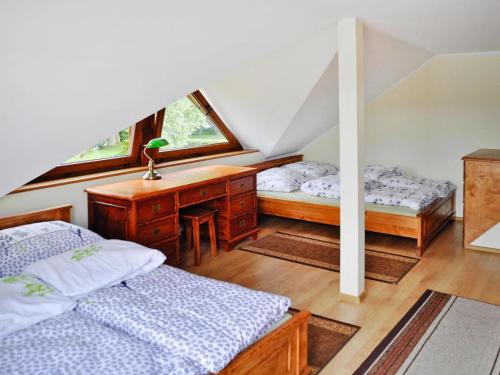 1 Schlafzimmer mit 2 Betten, einem Schreibtisch und einem Fenster in der Unterkunft Holiday house by the lake with a fireplace in Rosnowo