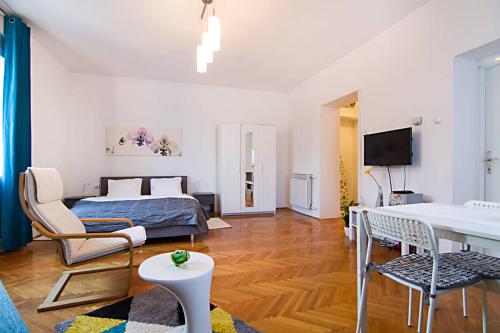 1 dormitorio con 1 cama, mesa y sillas en Cosy Studio Apartment 2 en Zagreb