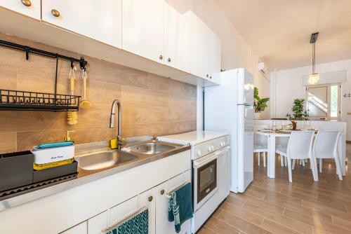 une cuisine avec un évier et un réfrigérateur blanc dans l'établissement Sea Spritz & Sun -Accesso Mare-Clima- Parcheggio, à Torre San Giovanni
