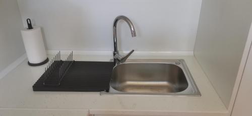 un lavandino con rubinetto e grata nera di Apartamento zona Parque Comercial a Mojácar