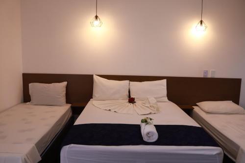 two beds in a hotel room with at Portal Da Mata in Santa Fé do Sul