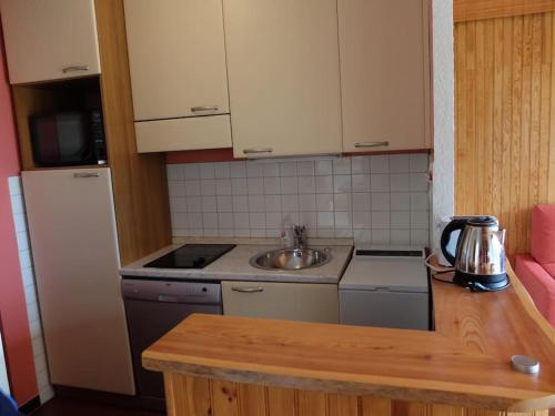 une petite cuisine avec un évier et un réfrigérateur dans l'établissement Grand T2 Orcières vue panoramique, à Orcières