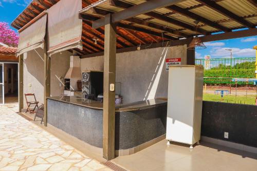 a outdoor kitchen with a counter and a refrigerator at Portal Da Mata in Santa Fé do Sul