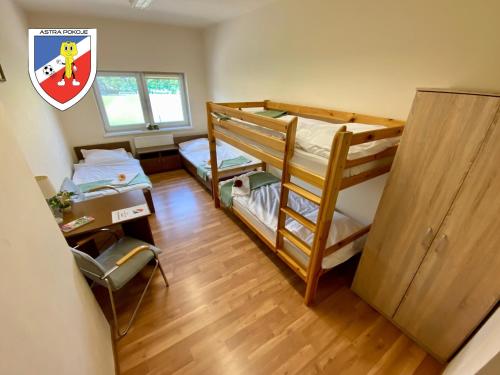 Cette chambre comprend deux lits superposés et un bureau. dans l'établissement Pokoje Astra, à Spytkowice