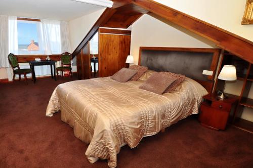 a bedroom with a large bed and a table at Pension & Spa de Watertoren in Zandvoort