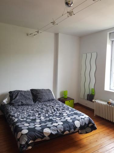 une chambre avec un lit avec une couette noire et blanche dans l'établissement 2 Chambres d 'hôtes chez un particulier avec piscine, à Saint-Leu-la-Forêt