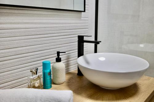 a bathroom with a white bowl sink on a wooden counter at Holiday Home TiA in Split