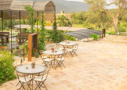 a group of tables and chairs on a patio at ECOTurisme Can Buch HOTEL in Sant Aniol de Finestras