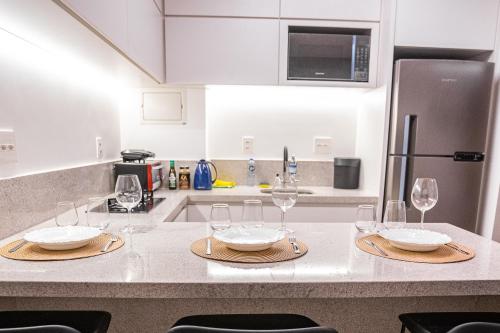 a kitchen with a table with wine glasses on it at Apartamento novo de alto padrão e aconchegante#223 in Brasilia
