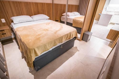 a bedroom with two beds and a mirror at Apartamento novo de alto padrão e aconchegante#223 in Brasilia