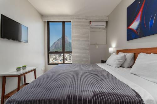 1 dormitorio con 1 cama grande y ventana grande en 180m PRAIA DO LEBLON, 2 Suítes, Vista Mar, ANDAR ALTO, Piscina etc, en Río de Janeiro