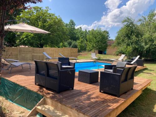 une terrasse en bois avec des chaises et une piscine dans l'établissement Les escales Périgourdines, Lucie, 3 étoiles, à Trémolat