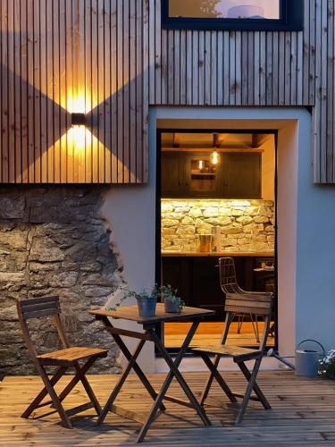une table et deux chaises devant un bâtiment dans l'établissement La Petite Grange - Spa Balnéo, à Vigneux-de-Bretagne